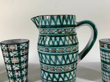 four cups and a pitcher sitting on a table