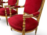 two red chairs with gold trim and a red velvet upholstered