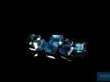 some very pretty blue crystals on a black surface