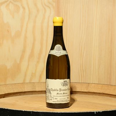 a bottle of wine sitting on top of a barrel