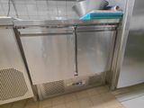 un réfrigérateur en acier inoxydable dans une cuisine, avec une casserole posée dessus