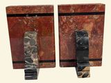 pair of red marble bookends with black handles on a white background