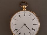 une montre de poche en or avec des chiffres romains sur le cadran