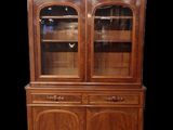 a wooden china cabinet with glass doors and drawers