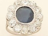 an image of a ring with a blue stone surrounded by white diamonds
