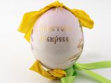 a pink and yellow ornament with a yellow bow on it