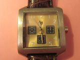 une image représentant une montre-bracelet posée sur un fond rose