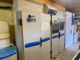 une rangée de réfrigérateurs dans une cuisine au sol en damier