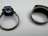 two silver rings with a blue stone sitting on top of each other
