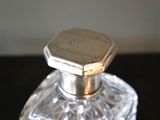 a glass bottle with a silver lid on a table