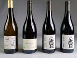 quatre bouteilles de vin sont alignées sur une table