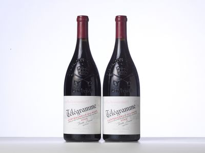 two bottles of red wine sitting on top of a table