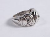 silver ring with spiral design on top of it on a white surface
