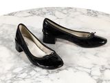 une paire de chaussures noires posée sur une table en marbre, sur fond blanc