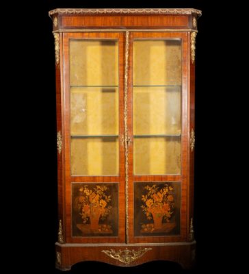 an antique wooden cabinet with glass doors and gold trimmings