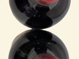 two bottles of wine sitting on top of each other