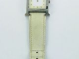 un gros plan d'une montre sur une surface blanche avec un fond blanc
