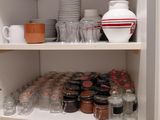many jars and cups on the shelves in the kitchen