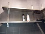 a metal shelf with a bottle of shampooe and a bottle of lotion on top of it