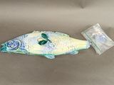 un objet en forme de poisson posé sur une table, à côté d'un sac en plastique