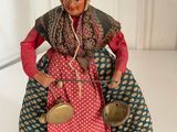 a figurine of a woman sitting on a chair