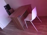 a desk with a chair and a microwave in the corner