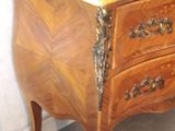 a wooden chest of drawers with a marble top