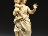a carved ivory figurine of a woman holding a child