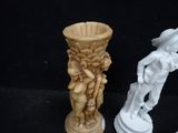 two figurines sitting next to each other on a black surface