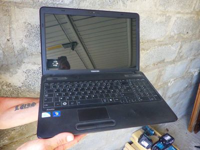 une personne tenant un ordinateur portable à la main