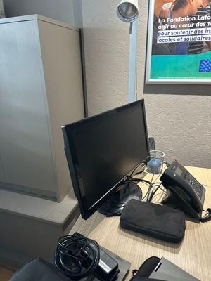 un bureau sur lequel se trouvent un ordinateur, un téléphone et d'autres appareils électroniques