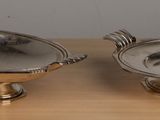 pair of silver plated dishes on wooden table with white background