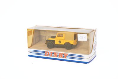 un petit camion jaune dans une boîte, posé sur une surface blanche