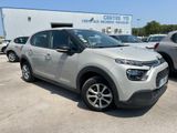 Une Citroën argentée est garée devant un immeuble