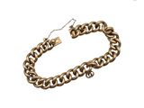 gros plan d'un bracelet en chaîne en or sur fond blanc