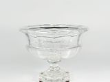 a clear glass bowl on a pedestal on a white background