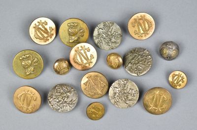 several gold and silver buttons with symbols on them on a gray surface
