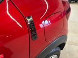 a close up of a red car with a sticker on it