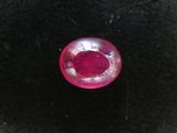 a close up of a red diamond on a black surface