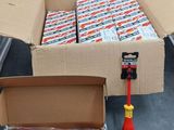une boîte remplie de piles et un marteau à côté d'un carton de piles