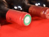 several bottles of wine are lined up on a red surface