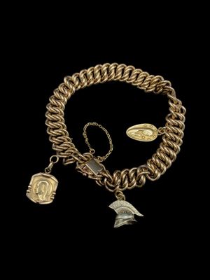 un gros plan sur un bracelet à chaîne en or orné de breloques
