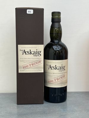 une photo montrant une bouteille de whisky posée à côté d'une boîte sur une table