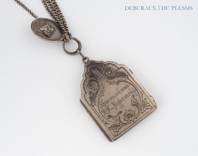 a silver necklace with a book on it on a white surface