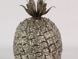 a silver pineapple sitting on a white surface