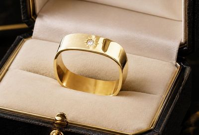a gold ring with a diamond in it in a box