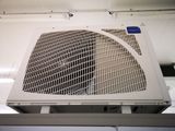a white air conditioner that is hanging from the ceiling