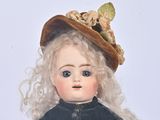 a small doll that is wearing a hat and dress