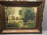 an oil painting of a landscape with trees in a gold frame on a white surface