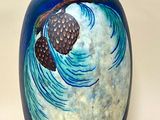 un vase bleu orné d'une image représentant un pin